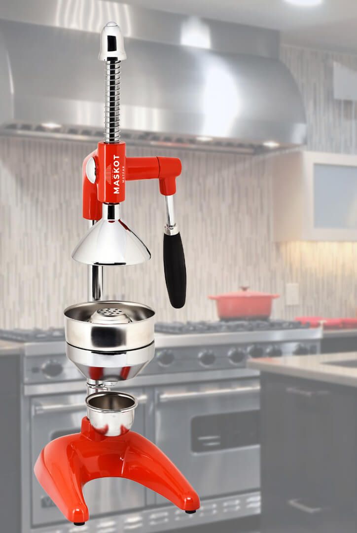 Red commercial citrus juicer in a professional kitchen